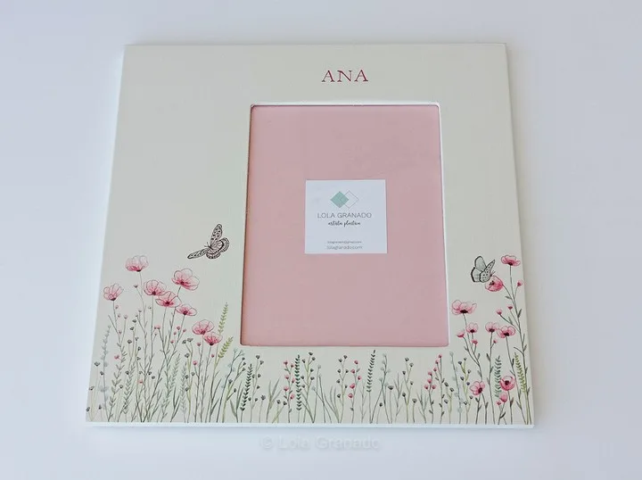 Marco de madera crema con flores silvestres, mariposas y el nombre Ana en rosa